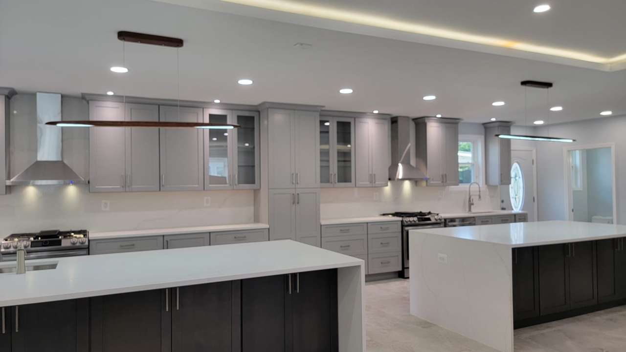 Kitchen after the DYS remodel with two islands, new cabinetry, and new lighting