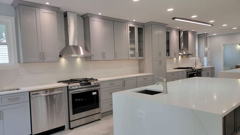 Finished double-island kitchen with bright surfaces and modern pendant lighting