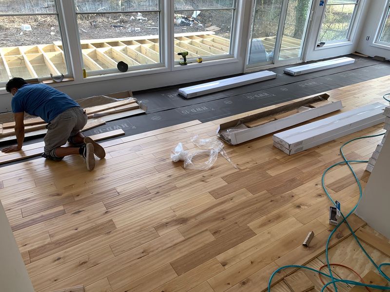 Hardwood flooring installation in progress with staggered layout