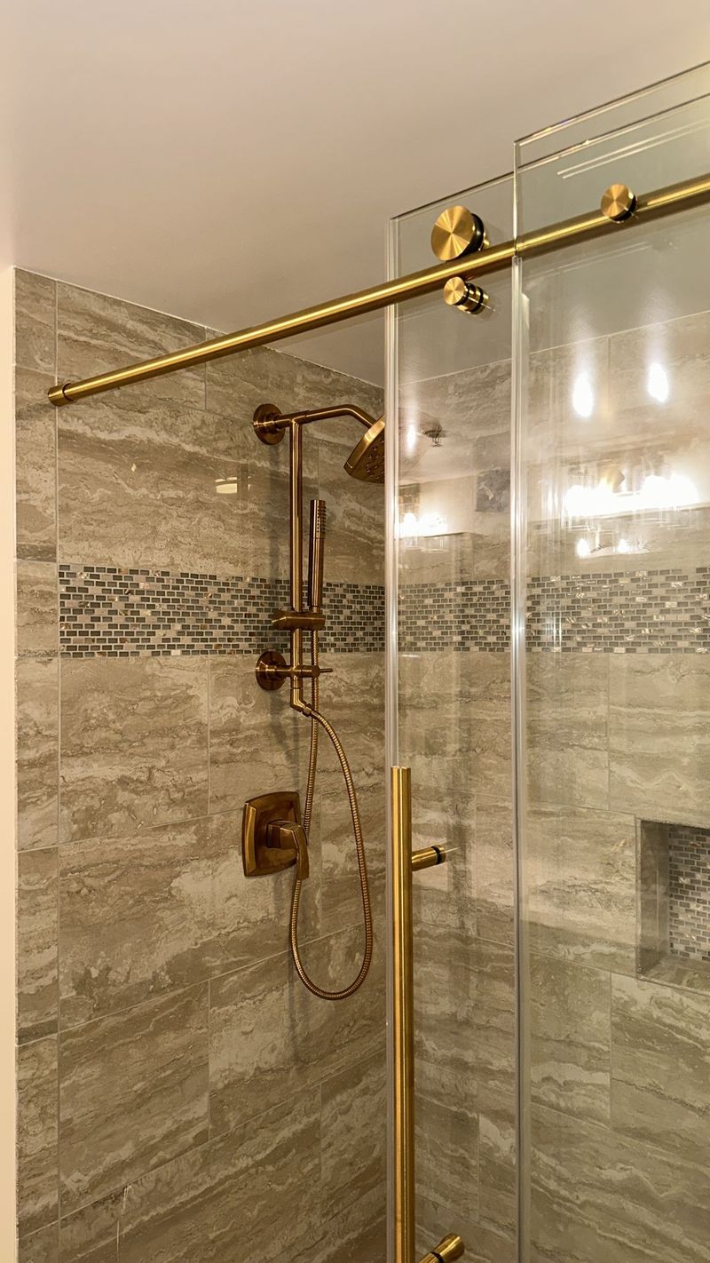 Layered gray tile shower with built in bench