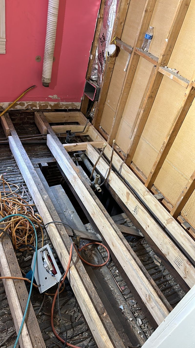 New lumber reinforces the open bathroom floor and wall framing.
