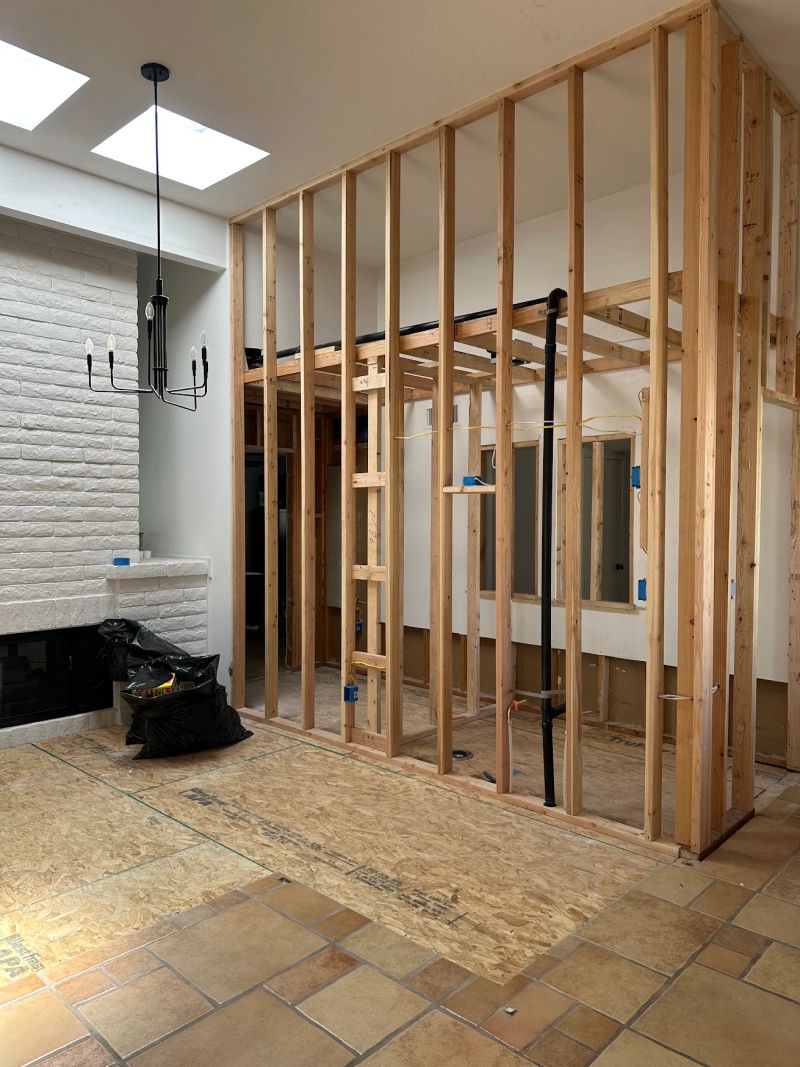 The former sunken wet bar framed up to floor level with new powder room and closet walls.