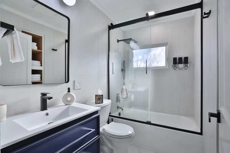 White tiled shower with a matte black glass enclosure