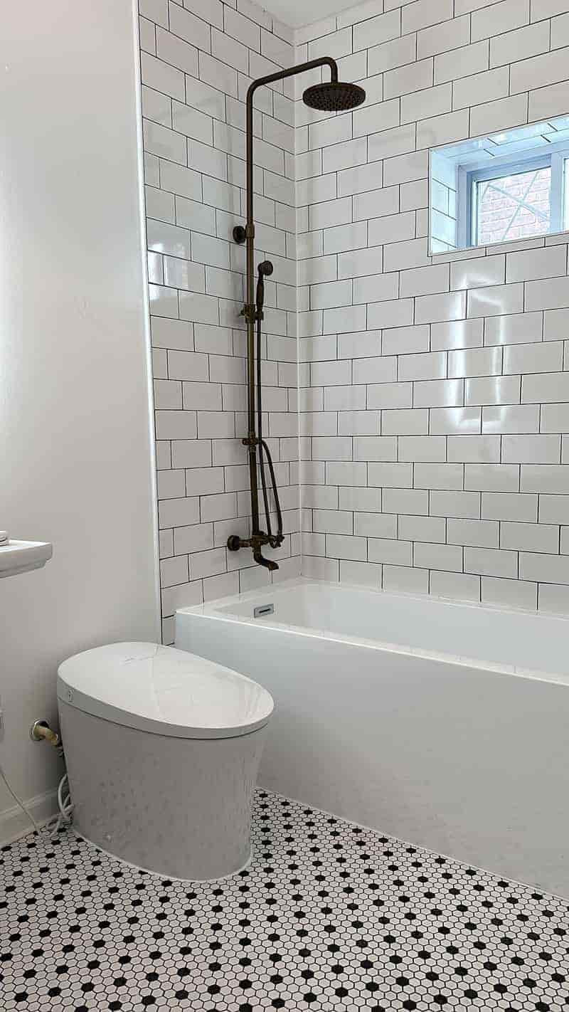 Bath with white subway wall tile and black and white hex floor tile