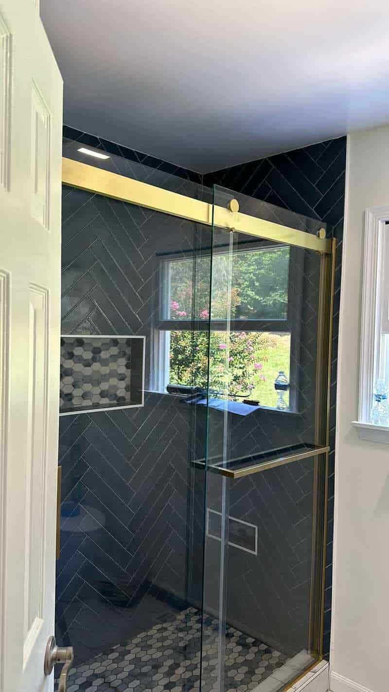 Dark herringbone shower seen through its glass enclosure