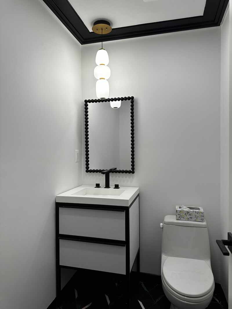 Powder room with modern lighting and a dark vanity
