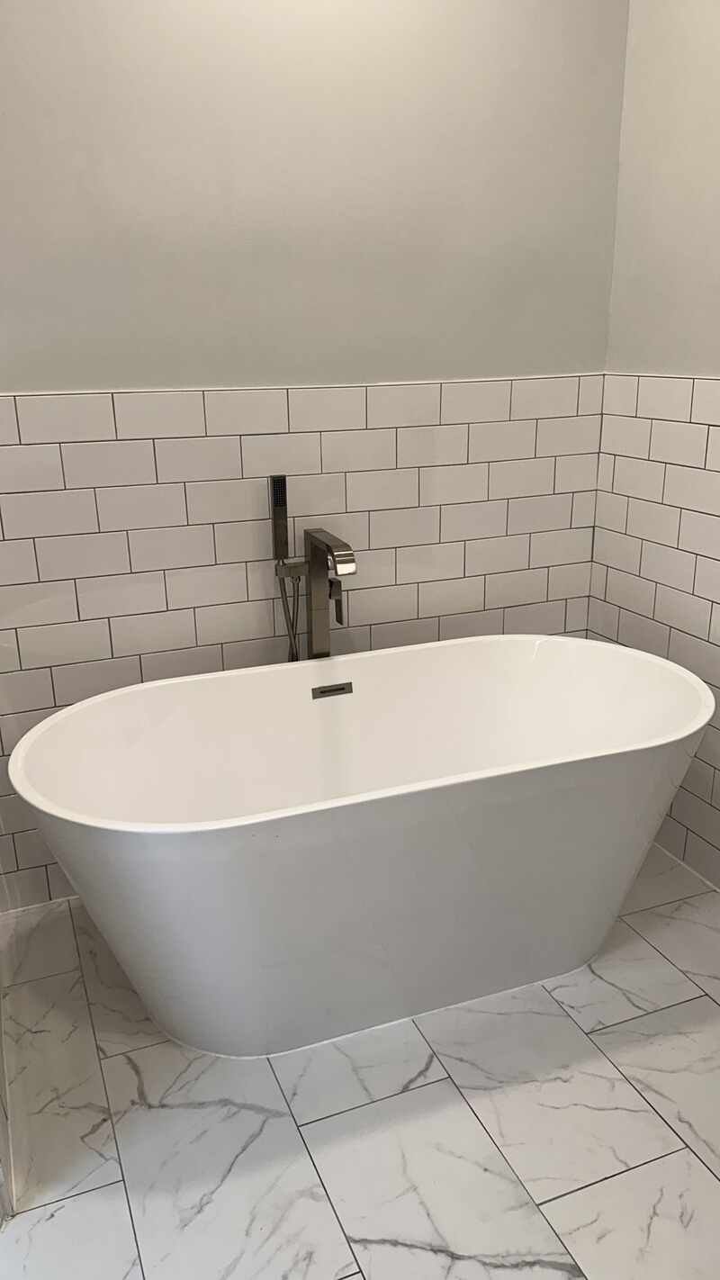 Freestanding tub with coordinated wall tile and fixtures