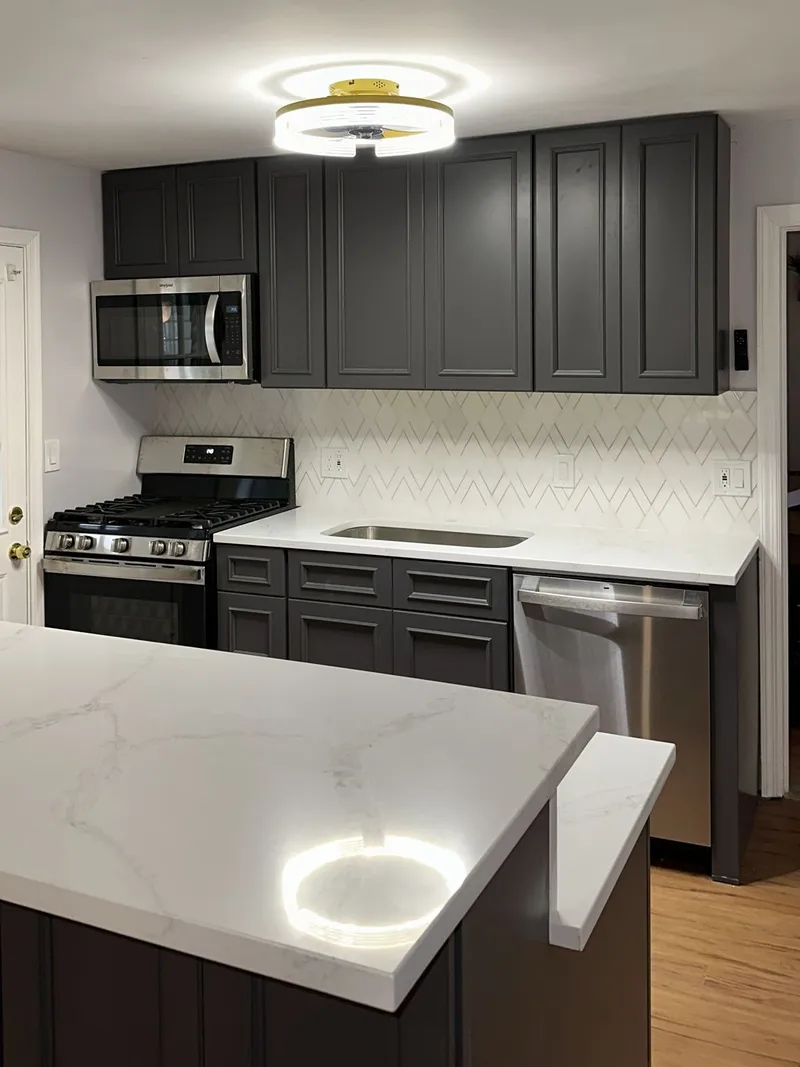 Finished open concept kitchen with charcoal shaker cabinets and gold hardware